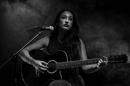 Naklejka beautiful young lady playing acoustic guitar