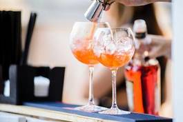 Plakat barman preparing a cocktails/barman added ingredients in a cocktail