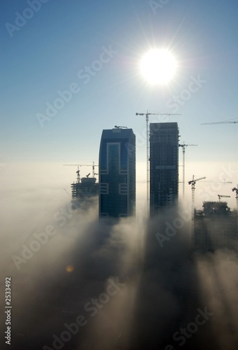 Naklejka niebo słońce dubaj budynek mgła