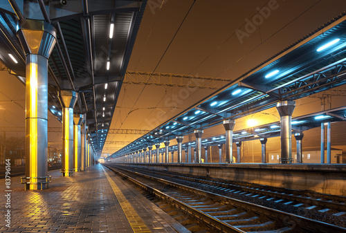 Plakat Railway station at night. Train platform in fog. Railroad