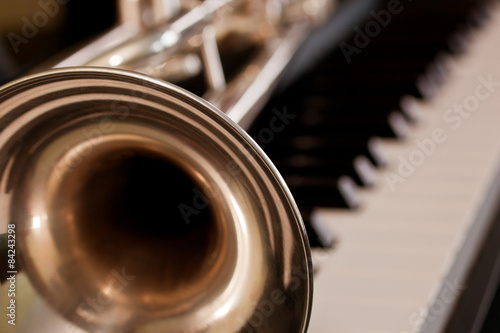 Naklejka Trumpet segment closeup lying on piano keys