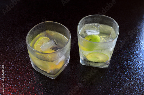 Naklejka Lemonade served on a dark marble bar with a lime