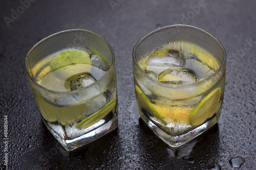 Naklejka Lemonade served on a dark marble bar with a lime