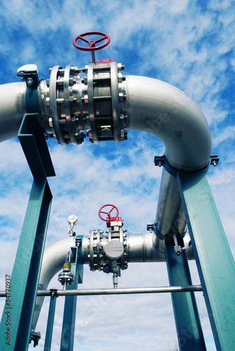 Fotoroleta Industrial zone, Steel pipelines and valves against blue sky