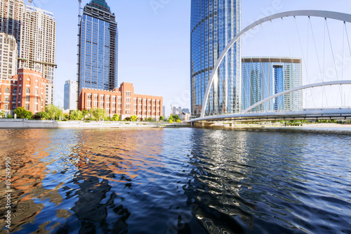 Naklejka skyscrapers,bridge and river in modern city during sunset