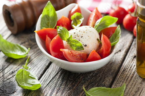 Naklejka Mozzarella cheese with basil and tomatoes in a bowl