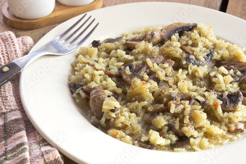 Fotoroleta Risotto with mushrooms on plate with fork