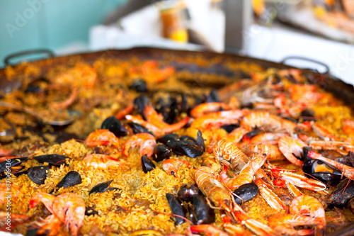 Fotoroleta Traditional paella with seafood in a market